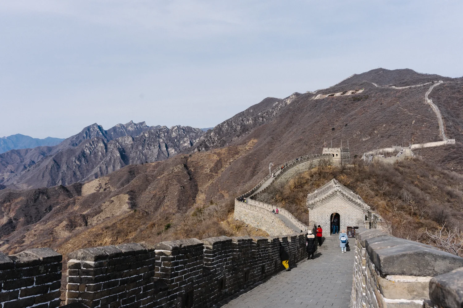 Wall descending toward a gateway and rising along mountain ridges