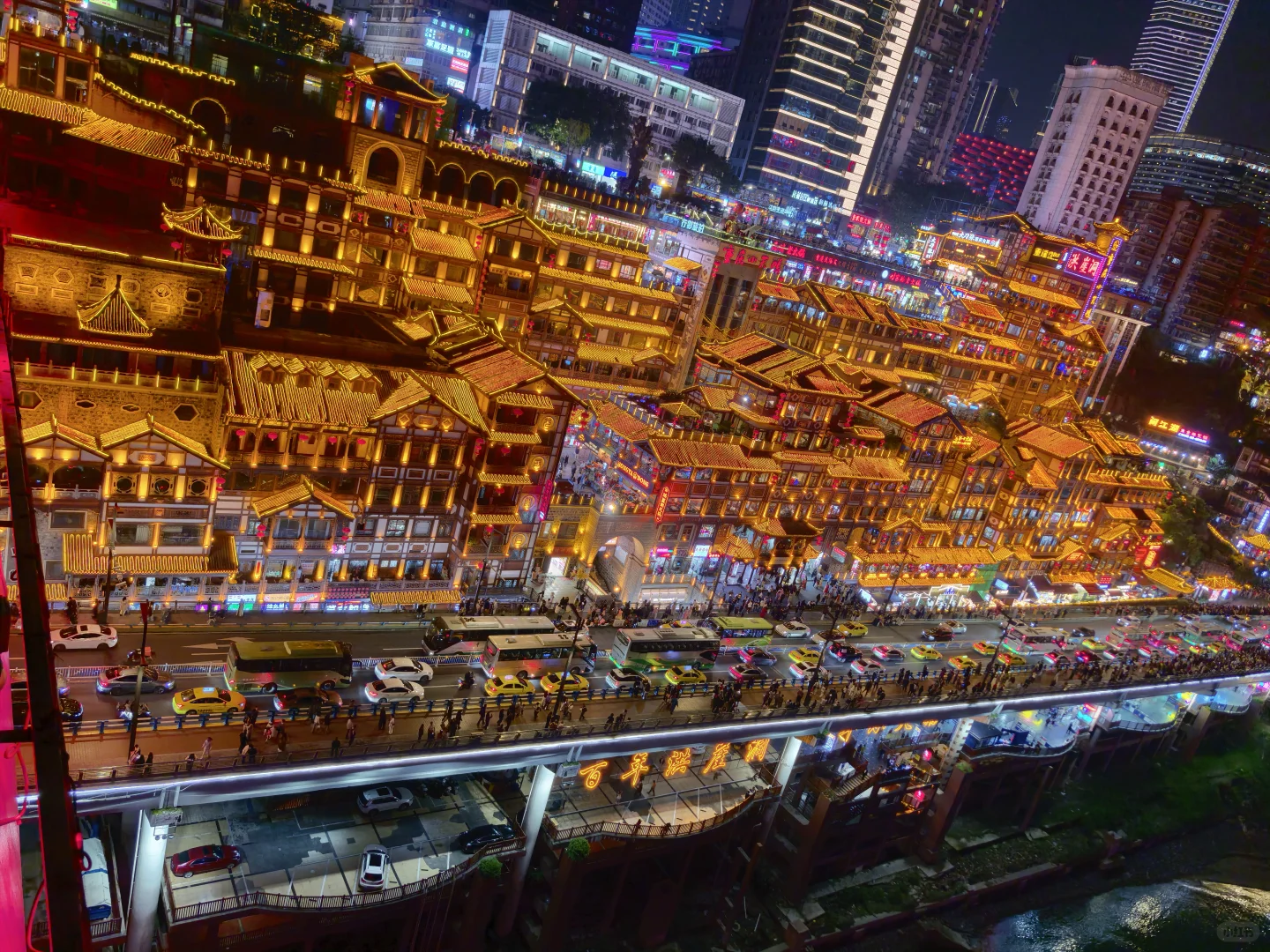 Hongyadong’s illuminated stacked buildings above a busy riverside road
