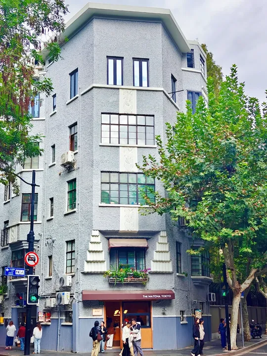 Street-corner architecture and small distant pedestrians in the Wukang walking area