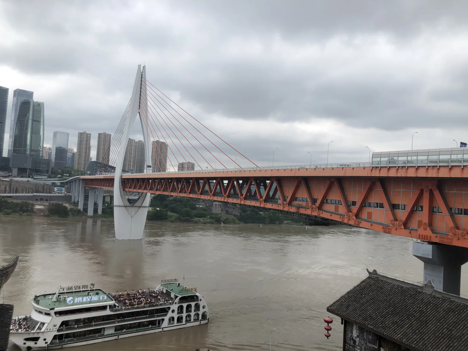 Orange Qiansimen Bridge spanning the Jialing River beside Chongqing’s skyline